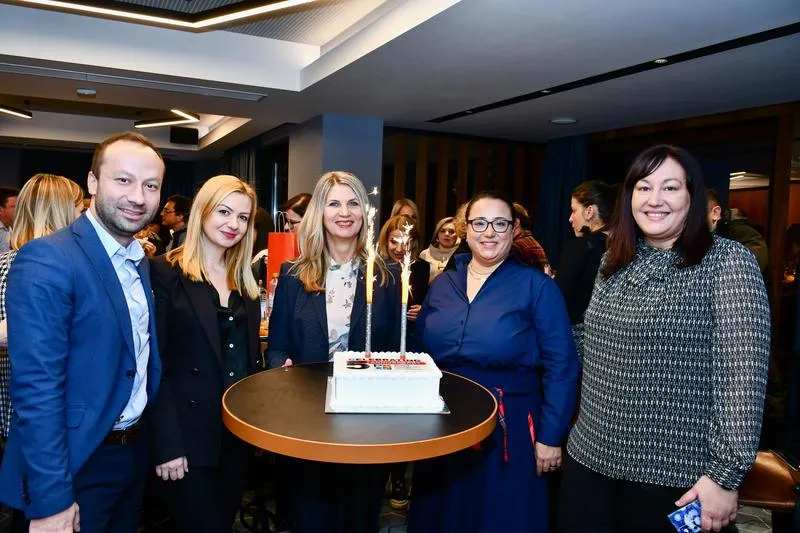 Board members around the chapter's fifth-anniversary cake, candles lit