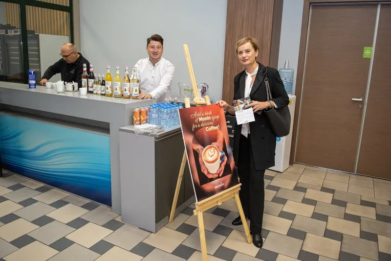 An attendee by the MONIN bar, where two bartenders are serving cocktails