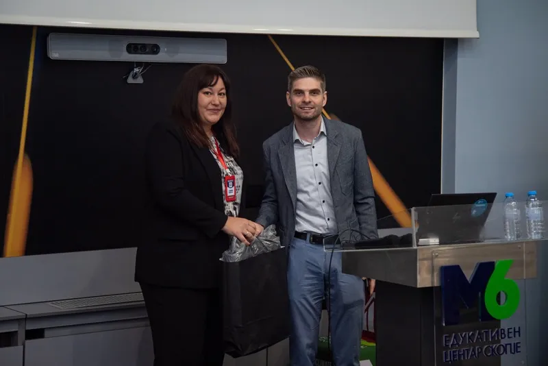 Two attendees at the M6 lectern after a session