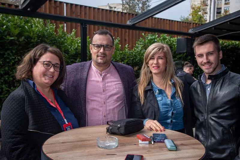 Four attendees around a table in the courtyard during the break